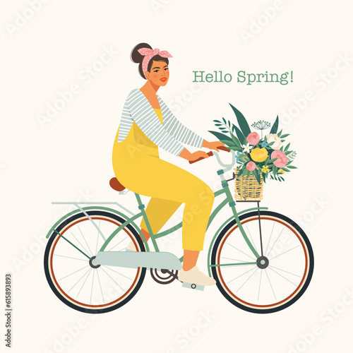Happy girl dressed in trendy clothes riding city bicycle with flower bouquet in front basket. Adorable young hipster woman on bike.