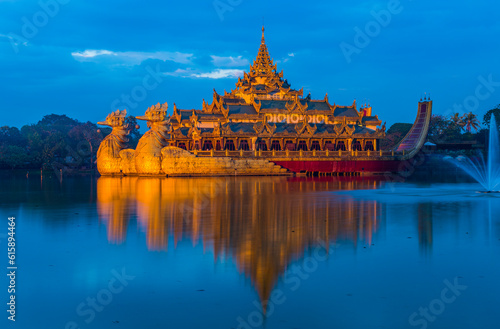 Golden Karaweik palace on Kandawgyi lake looks like an ancient royal barge. Twilight time. Yangon, Myanmar