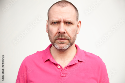 Portrait of casual mature man in pink t-shirt. © Designpics