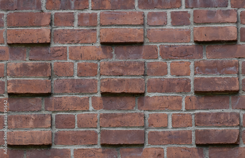 decorative red brick wall, running bond interspersed with protruding pairs of stacked bricks create a cubic geometric design background decorative red brick wall, running bond interspersed with protruding pairs of stacked bricks create a cubic geometric design background
