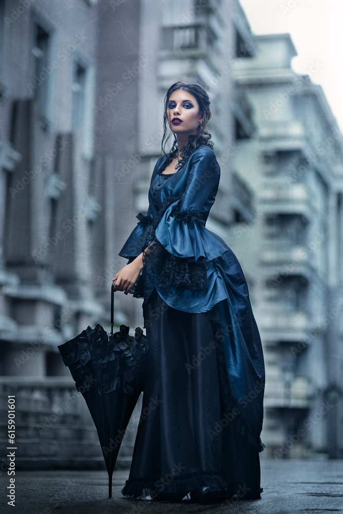 Fototapeta premium Outdoors portrait of a victorian lady in blue