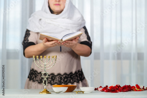 Fényképezés A Jewish woman in a white headscarf reads Tehillim before the wedding for a happy family life