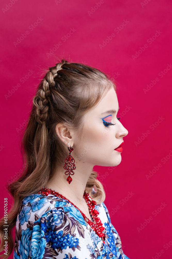 A girl in a folk costume on a red background A girl in a folk costume on a red background