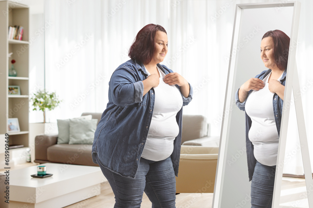 Overweight young woman standing in front of mirror Overweight young woman standing in front of mirror