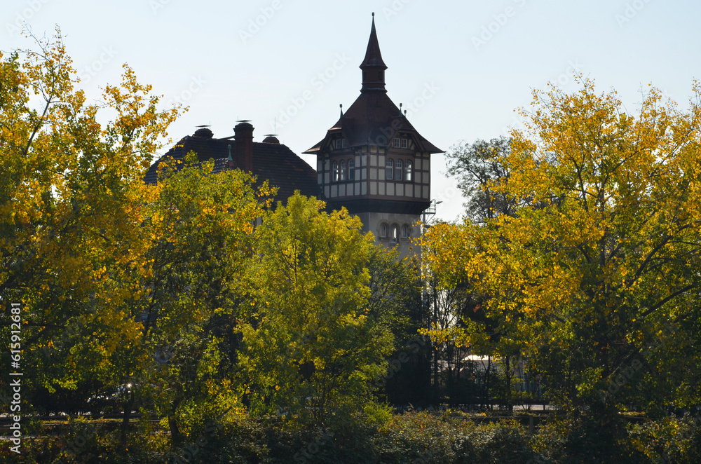 Old half-timbered house with square tower behind some autumn colorful trees on the Main river in Frankfurt Old half-timbered house with square tower behind some autumn colorful trees on the Main river in Frankfurt