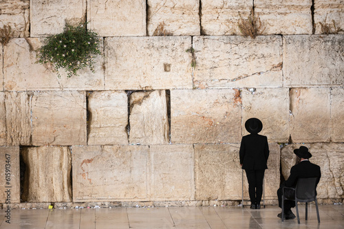 Two orthodox men praying by the western wall in Jerusalem.
