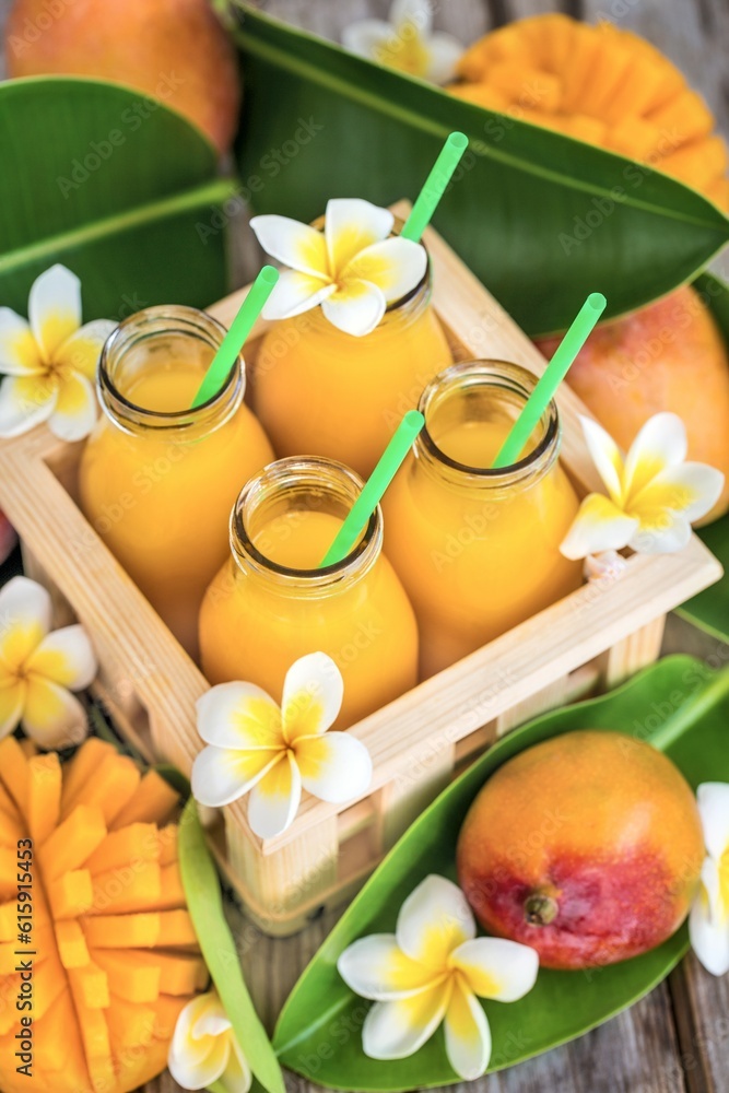 Fresh mango juice in small bottles in wooden box Fresh mango juice in small bottles in wooden box