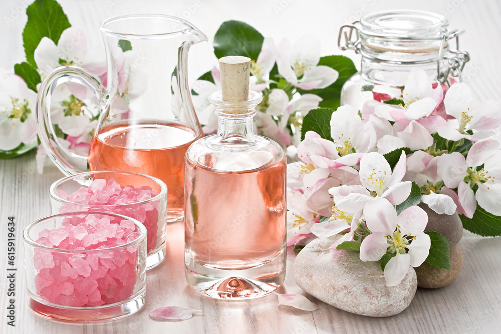 Aroma oil, sea salt, and apple blossom flower on wooden background Aroma oil, sea salt, and apple blossom flower on wooden background