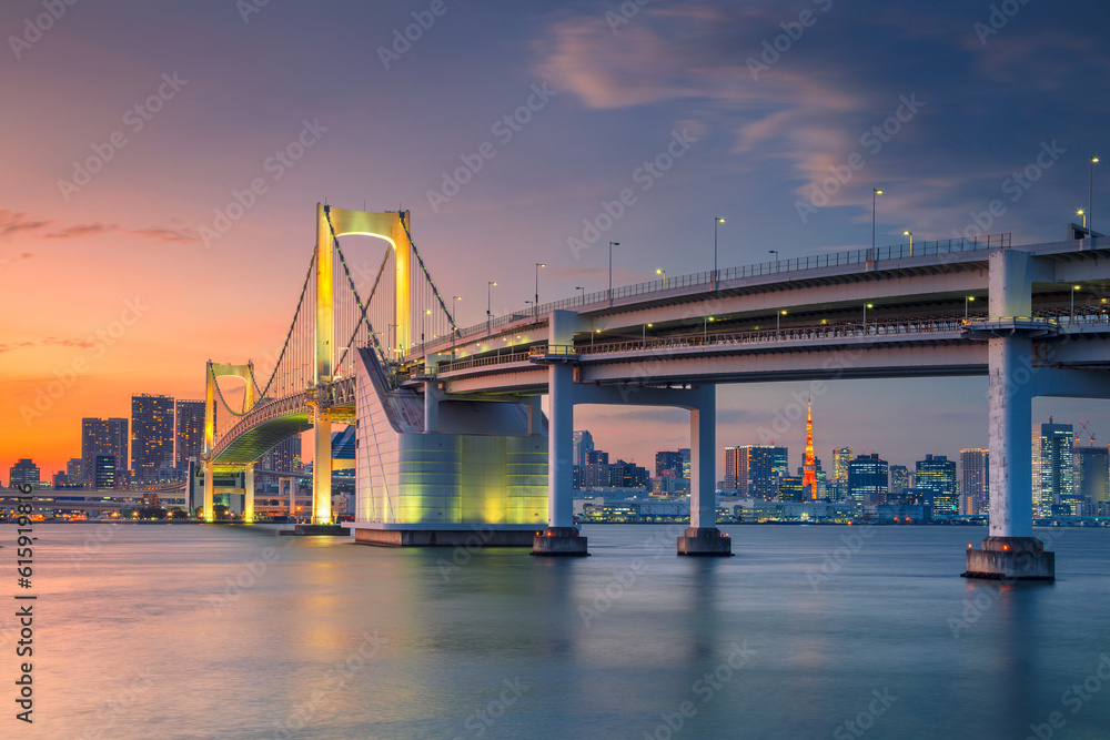 Cityscape image of Tokyo, Japan with Rainbow Bridge during sunset.
