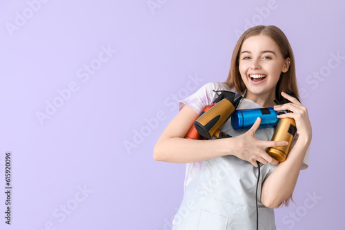 Female hairdresser with sprays and dryer on lilac background