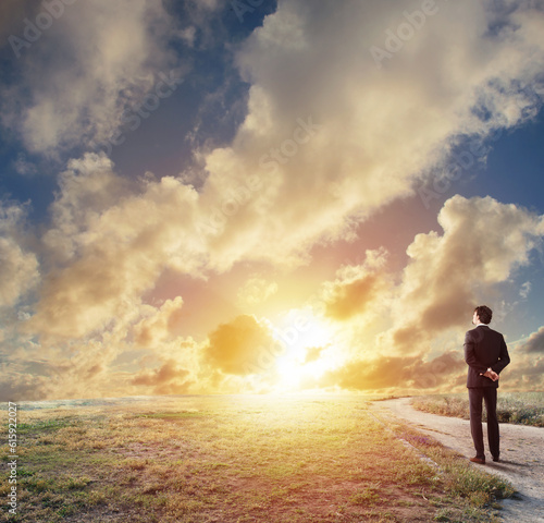 Businessman looks far during sunrise. Future and new business opportunity concept