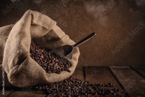 Coffee beans with jute bag and bailer on grunge background photo