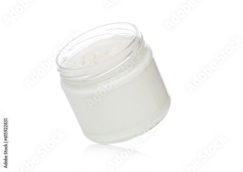 Glass container with sour cream dip and nachos chips on white background