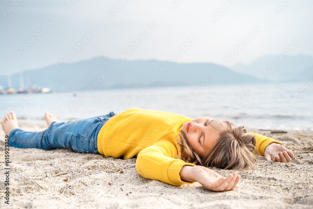 Lonely beautiful sad girl teenager lying sleeping on sand sea beach. Dreams,anxiety,worries about future,school friends,parents. Teen bullying, psychological problems in adolescent puberty period