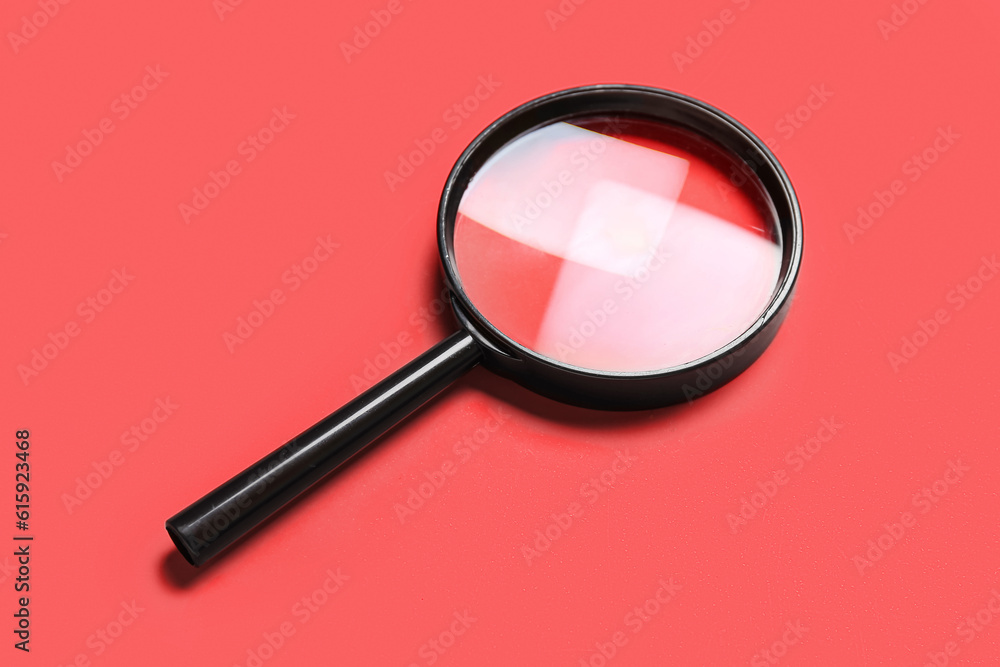 Black magnifier on red background Black magnifier on red background