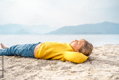 Lonely beautiful sad girl teenager lying sleeping on sand sea beach. Dreams,anxiety,worries about future,school friends,parents. Teen bullying, psychological problems in adolescent puberty period