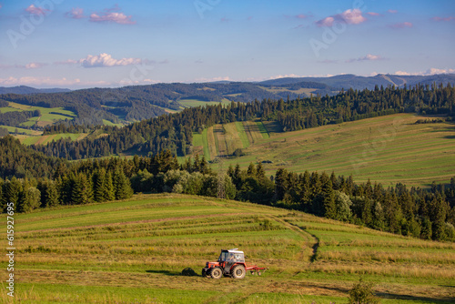 Fototapeta Naklejka Na Ścianę i Meble -  Tractor at the field on a hill in Spisz region, Poland