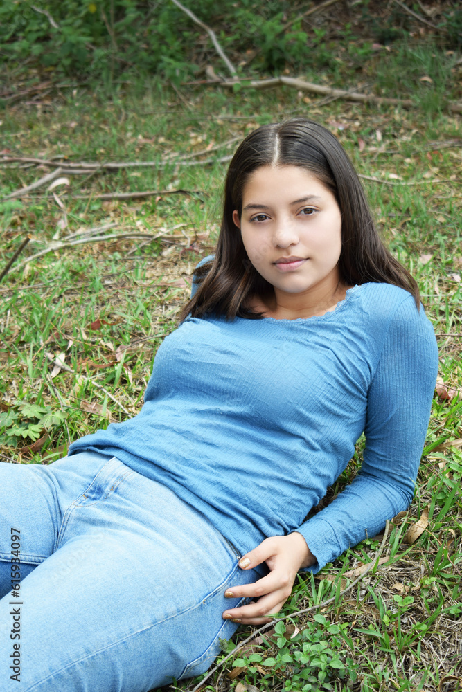 Mujer joven recostada sobre la grama en el parque. Concepto de relajación al aire libre.