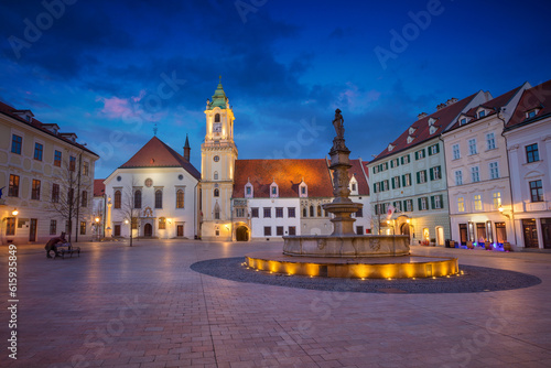 Cityscape image of the Main Square and Old Town Hall in Bratislava, Slovakia during twilight blue hour.