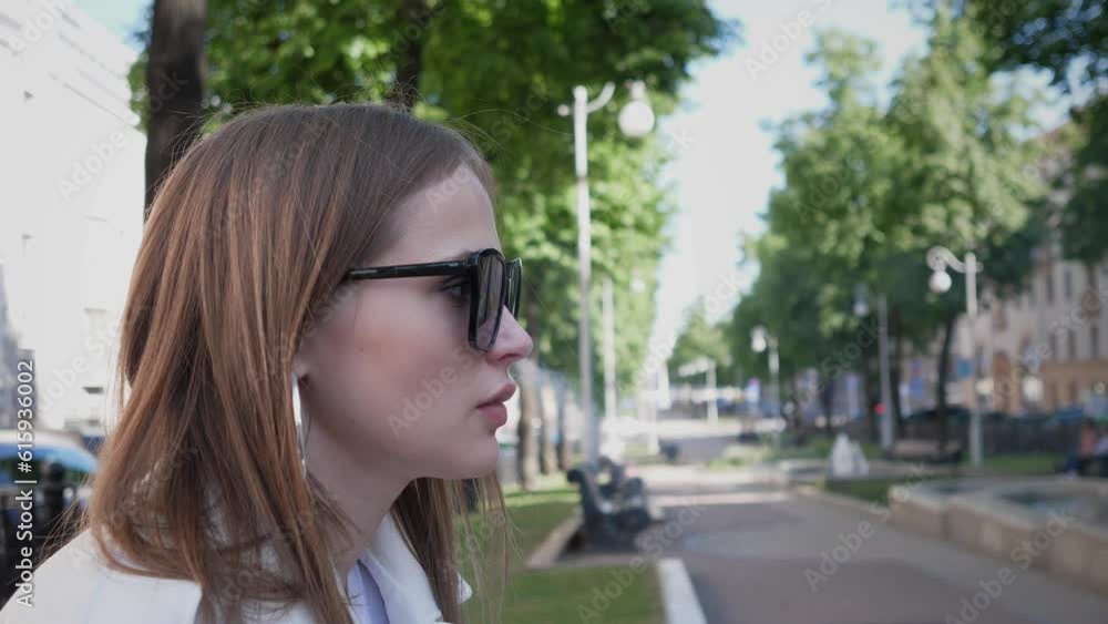 side view of a woman smoking a cigarette in the city on the street in summer side view of a woman smoking a cigarette in the city on the street in summer