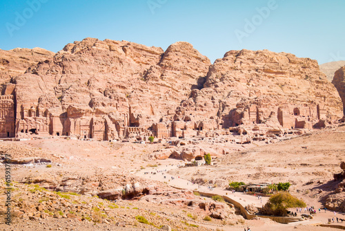 Tourists walk visit Petra historical landmark in Jordan on summer with scenic panorama of sacred tombs