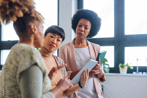 Africa-American employee talking with two unsatisfied female executives. © bernardbodo