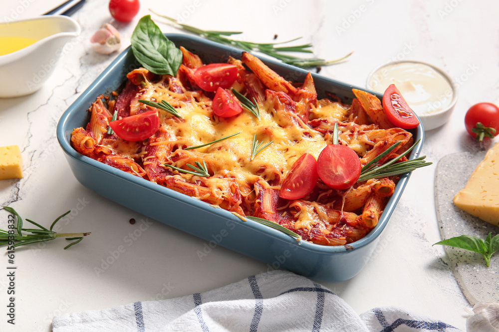 Baking dish of pasta with tomato sauce and cheese on white background Baking dish of pasta with tomato sauce and cheese on white background