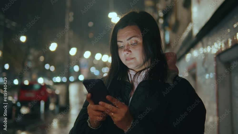 Portrait of a girl with a smartphone with an umbrella in the rain at night Portrait of a girl with a smartphone with an umbrella in the rain at night