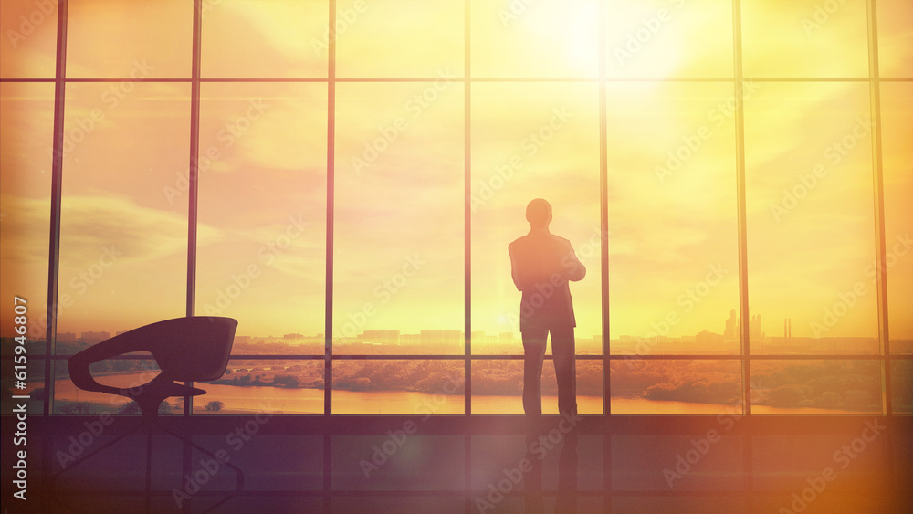 Silhouette of a man in a huge office in front of large windows. Silhouette of a man in a huge office in front of large windows.