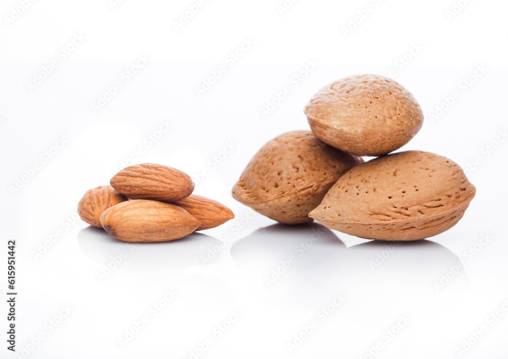 Raw almonds nuts with shell on white background with reflection Raw almonds nuts with shell on white background with reflection