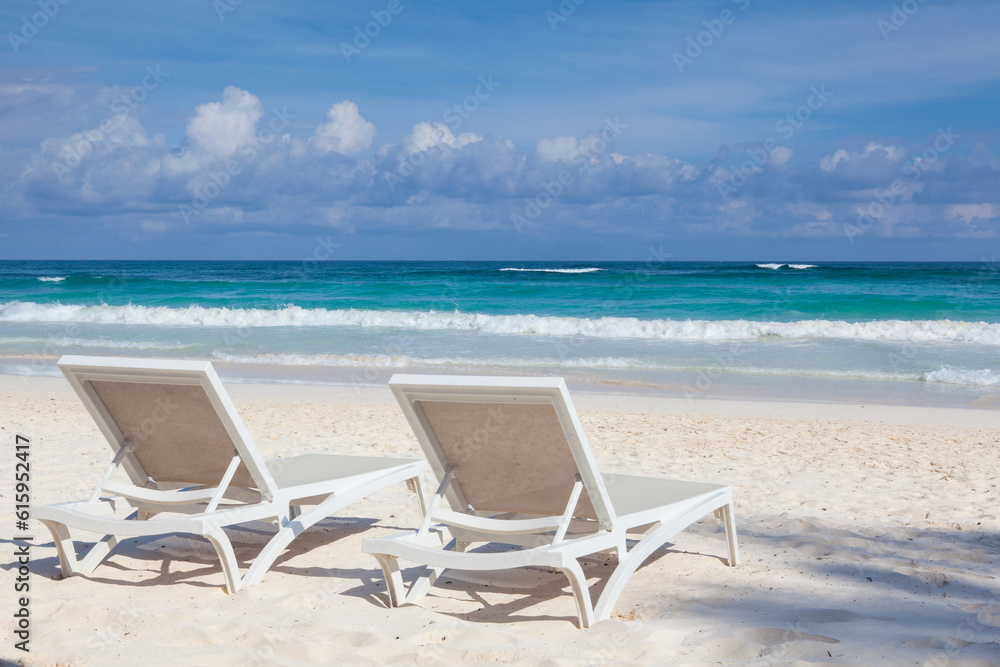 Two white beach chairs on the empty beach in Play del Carmen, Yucatan, Mexico