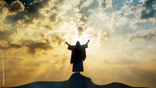 Fotografia, Obraz Silhouette of Jesus praying on a mount with sun rays and mystic clouds behind Him