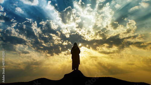 Silhouette of Jesus standing on a mount. photo