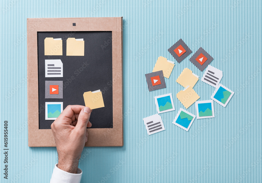 File selection, management and organization: user adding paper cut folders and icons to his smartphone screen File selection, management and organization: user adding paper cut folders and icons to his smartphone screen