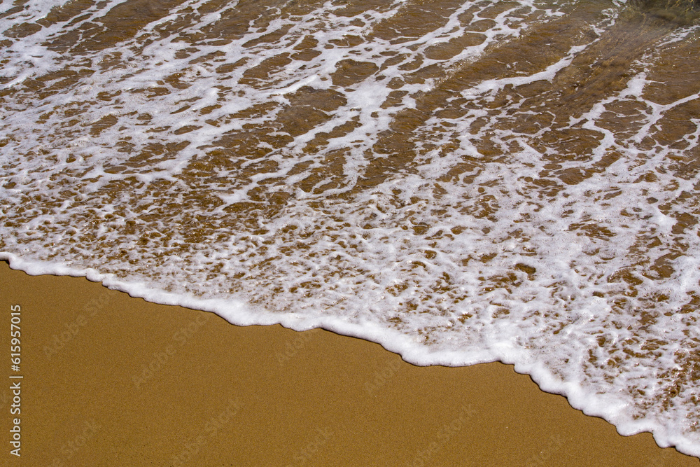 Beautiful waves with white foam on sand beach. Background. Beautiful waves with white foam on sand beach. Background.