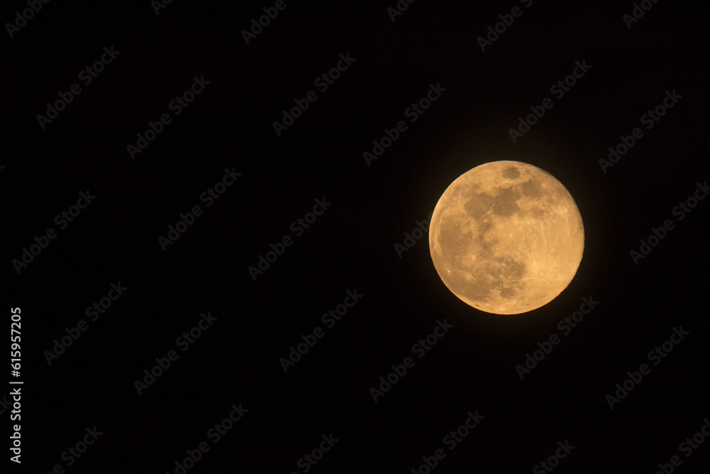 Obraz premium Blue Moon rising on 31 March 2018, landscape orientated image with Moon isolated on black background with text or copy space.