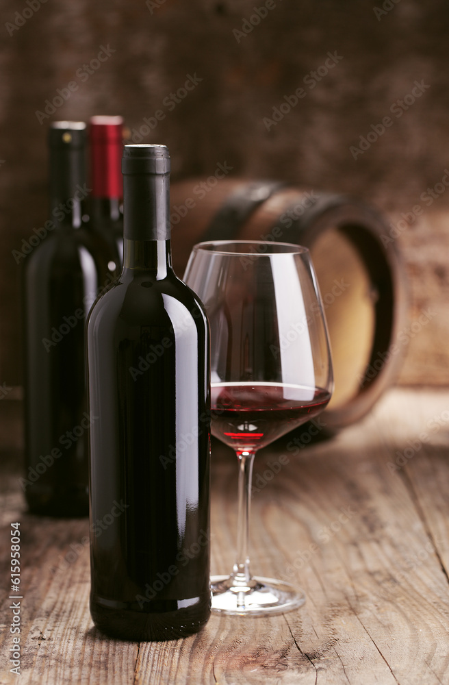 Wine bottles with barrel on wooden background Wine bottles with barrel on wooden background