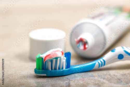 Toothbrush in the foreground and toothpaste on the shelf