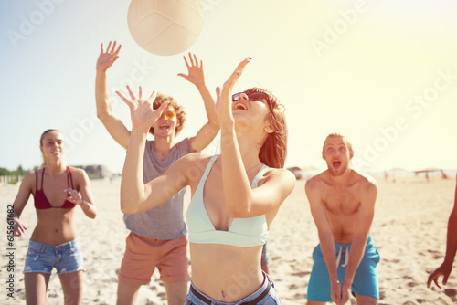 Group of happy friends playing at beach volley at the beach