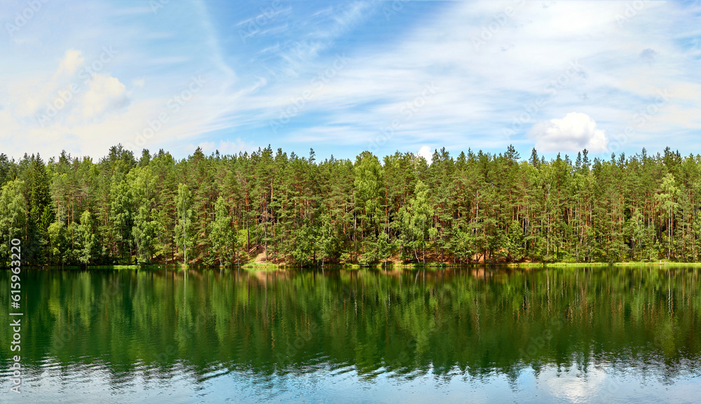 Forest lake with reflections of green trees