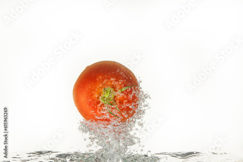 Tomato in the water on isolated studio background