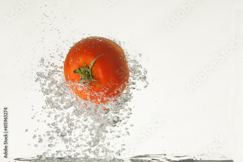 Tomato in the water on isolated studio background