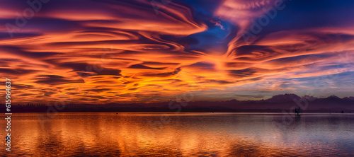 Incredible lenticular clouds in the sky during a sunset over the Varese lake photo