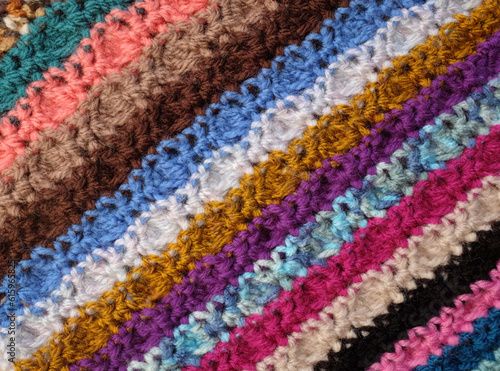 Diagonal stripes of crocheted stitches in multi-coloured wool  as abstract background texture
