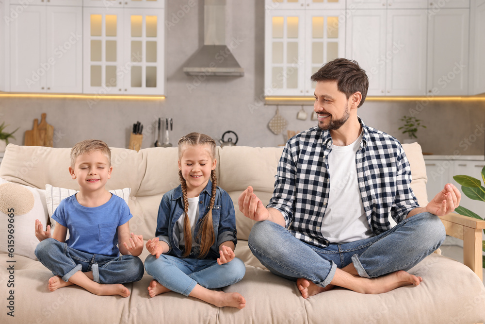 Father with children meditating together on sofa at home. Harmony and zen Father with children meditating together on sofa at home. Harmony and zen