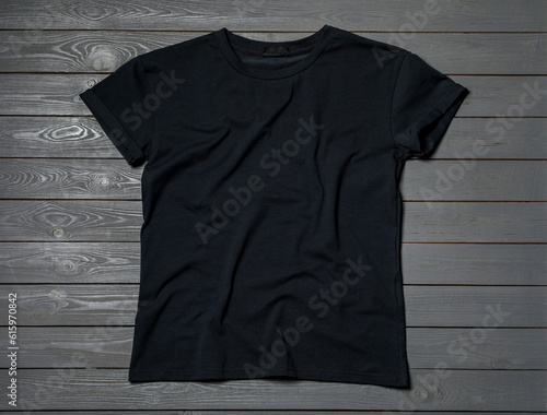Stylish black T-shirt on gray wooden table, top view