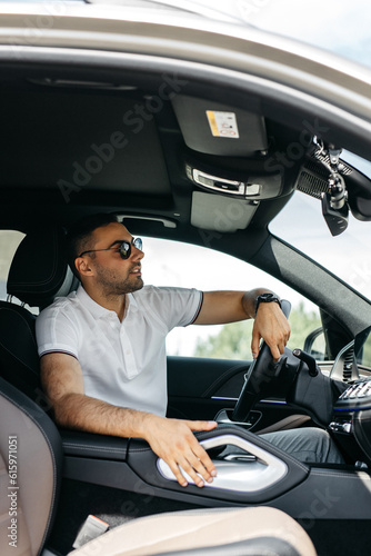 Side view of successful man holding hand on steering wheel and enjoying driving getting to enterprise meeting in time, positive male entrepreneur smiling in new automobile car © AvokadoStudio