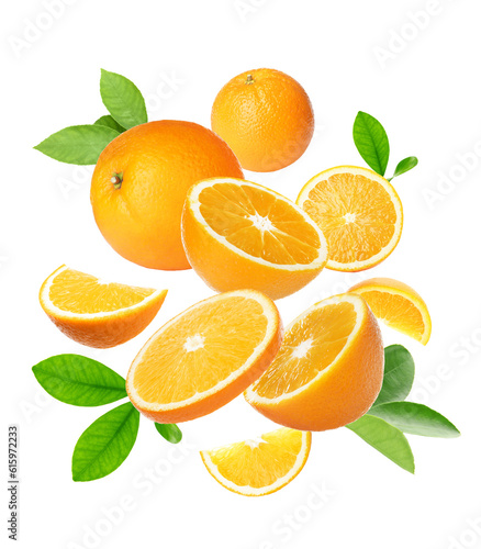 Cut and whole oranges with green leaves flying on white background