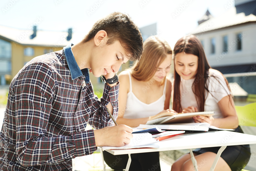 three high school students. students friends learn, do homework together, spend time in outdoor. three high school students. students friends learn, do homework together, spend time in outdoor.