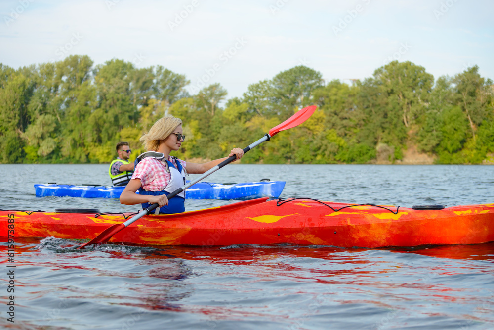 Young Happy Couple Paddling Kayaks on the Beautiful River or Lake